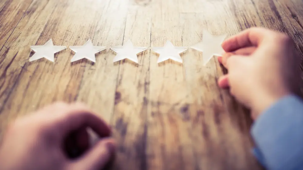 Tisch mit Händen und Sternen – © Warchi / iStock.com